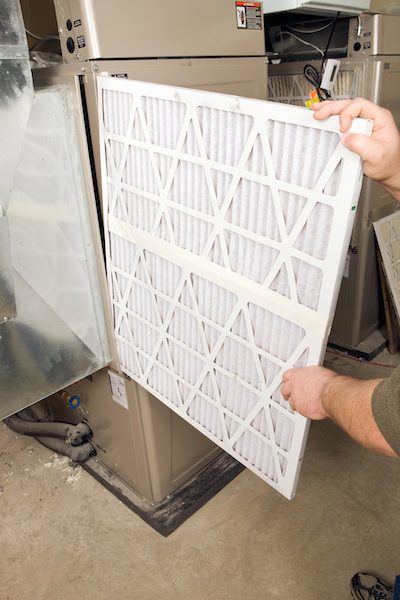 Furnace filter being changed in St. Louis, MO home. Superior Heating Cooling Plumbing blog image.